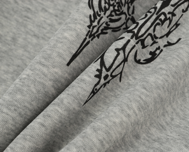 Close-up of heather gray hoodie fabric with black ornate graphic print and folds