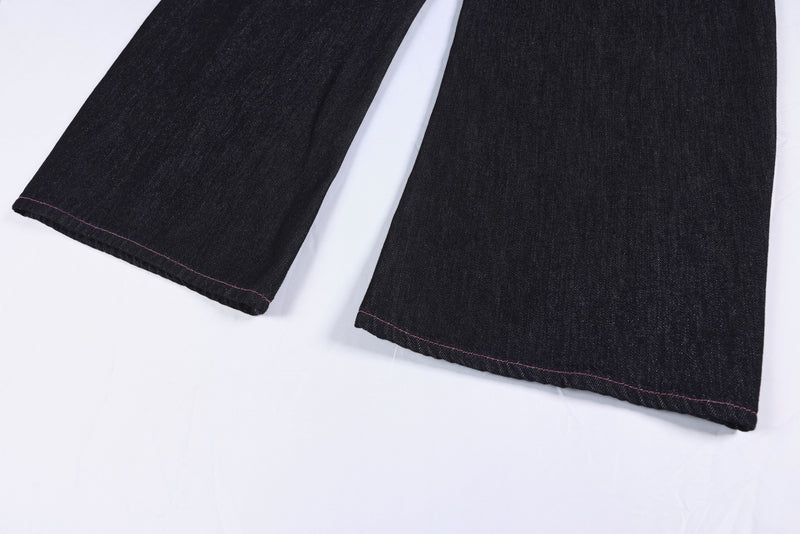 Close-up of the lower front leg hems on black wide-leg denim pants