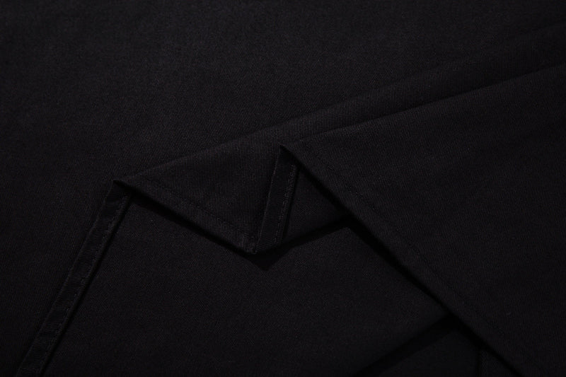 Close-up of black button-up shirt fabric with folded seams and subtle texture, styled for rock-inspired streetwear