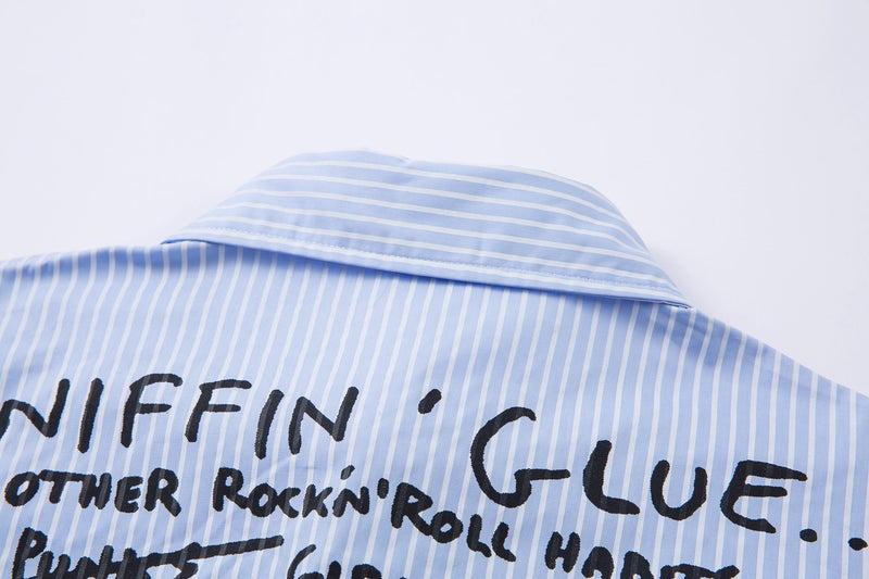 Close-up of the back collar on a light blue pinstripe shirt with printed graphic text