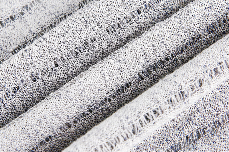 Close-up of gray textured knit fabric with open laddered stripes
