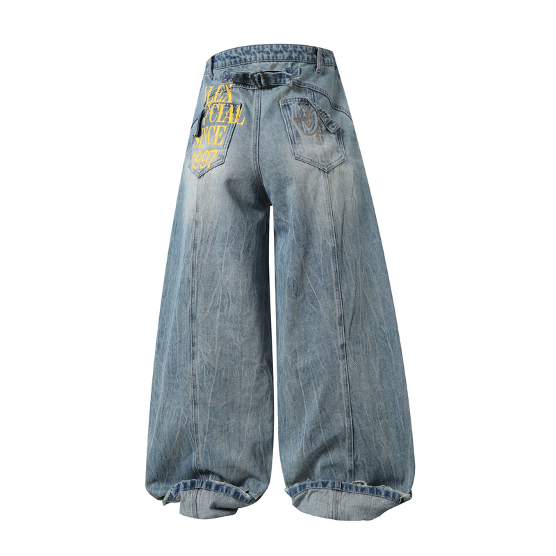 Back view of light wash wide-leg denim pants with graphic text and flap pockets