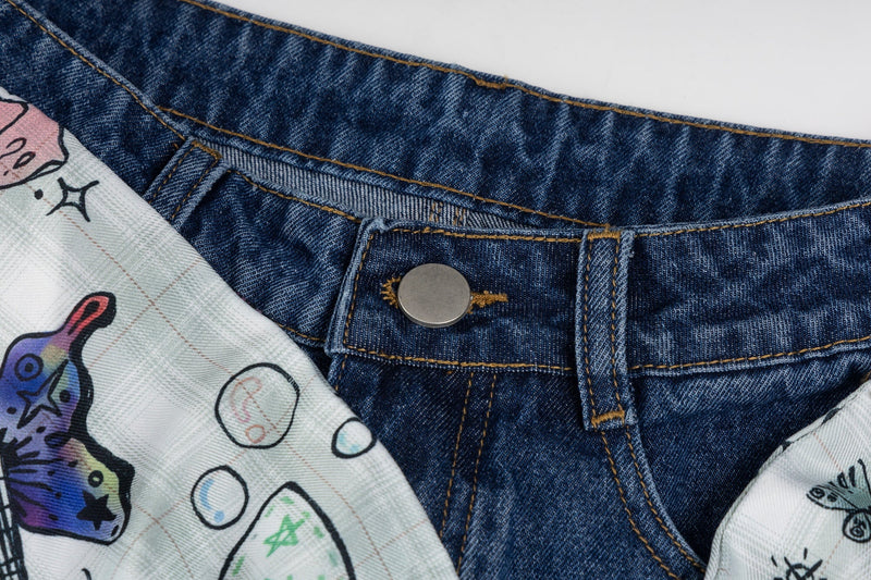 Close-up of blue jeans waistband with silver button and printed ribbon bow fabric