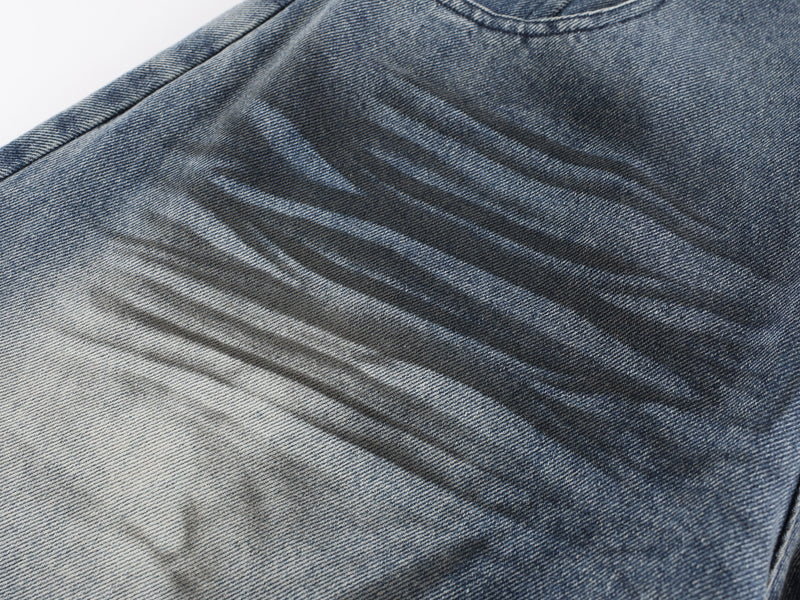 Close-up of faded denim fabric with wave-wash whiskering detail