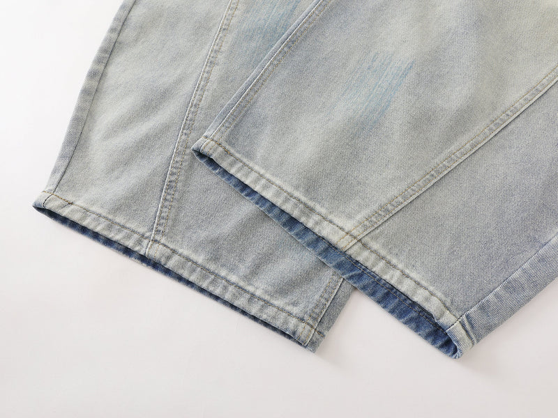 Close-up of hem on light wash wide-leg denim pants with folded cuff detail