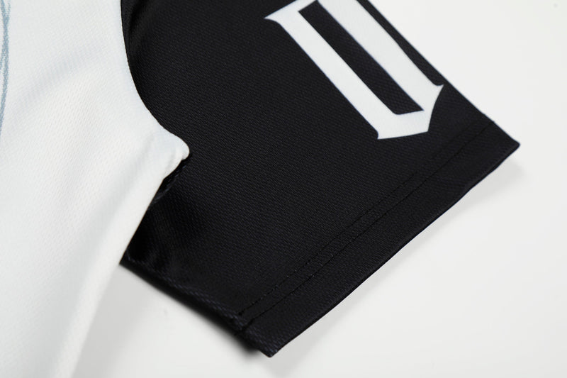 Close-up of a black mesh football jersey sleeve with white graphic detailing and stitched hem