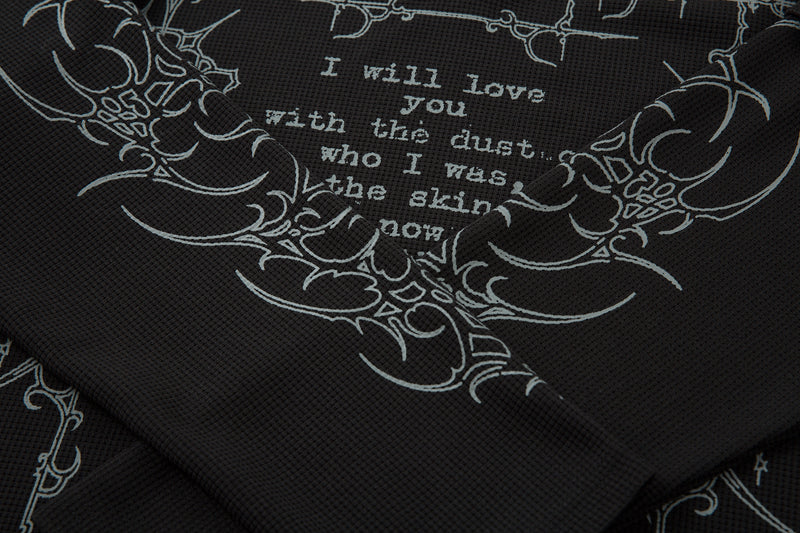 Close-up of black front print showing gray barbed graphics and partial poem text