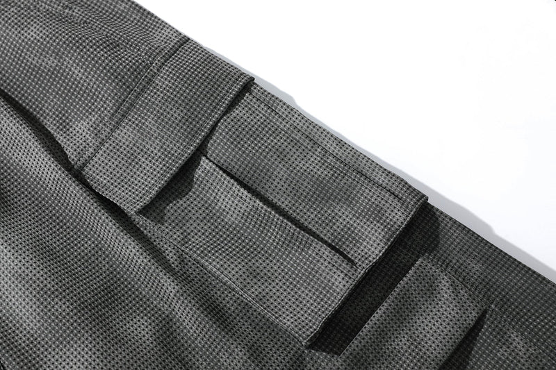 Close-up of black mesh cargo pocket and hem seam on the shorts leg