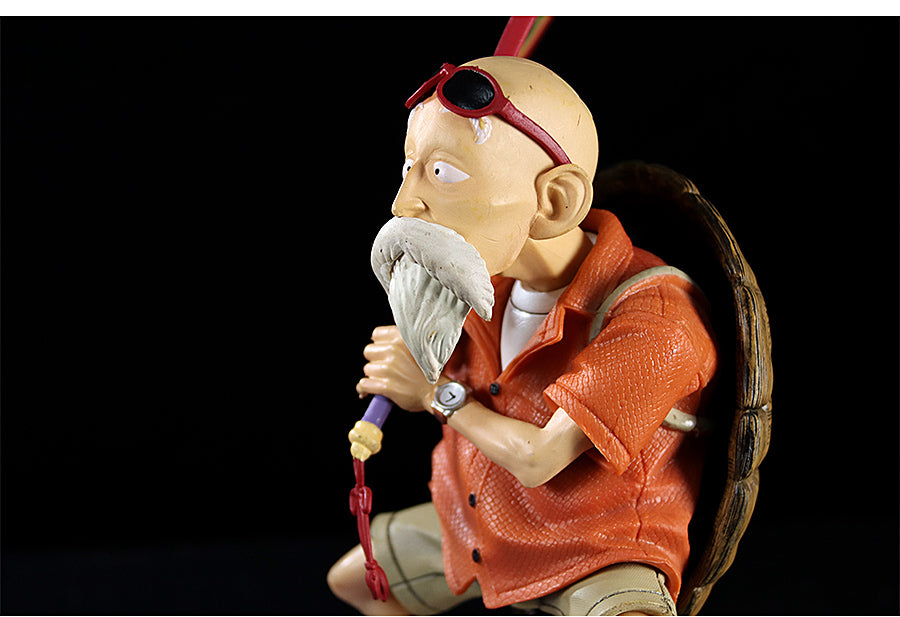 The Seakoff Master Roshi Collectible Figure displays the iconic Dragon Ball character at 18cm, featuring his white beard, bald head, sunglasses, orange clothing, and a large backpack. He is accompanied by his trusty stick and banana fan against a black backdrop in this premium action statue.