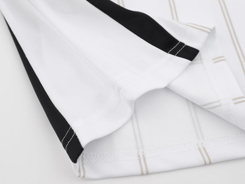Folded white mesh soccer jersey polo with black side panels and beige striped trim, shown in a clean studio close-up