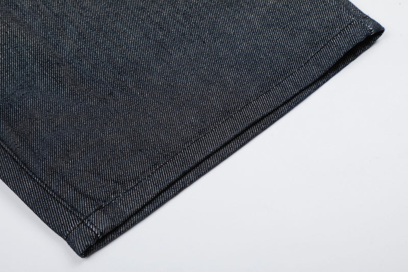 Close-up of raw hem on dark wash denim jorts