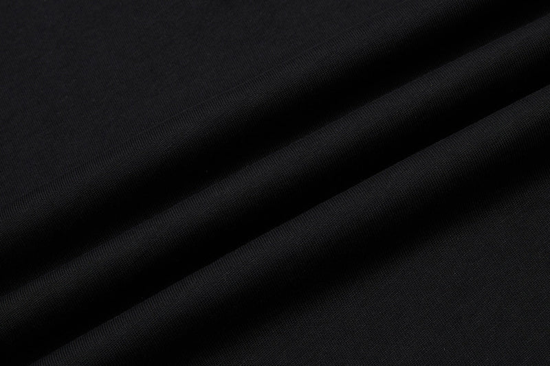 Close-up of black textured fabric with smooth diagonal folds, suited for a vintage men's music graphic polo shirt