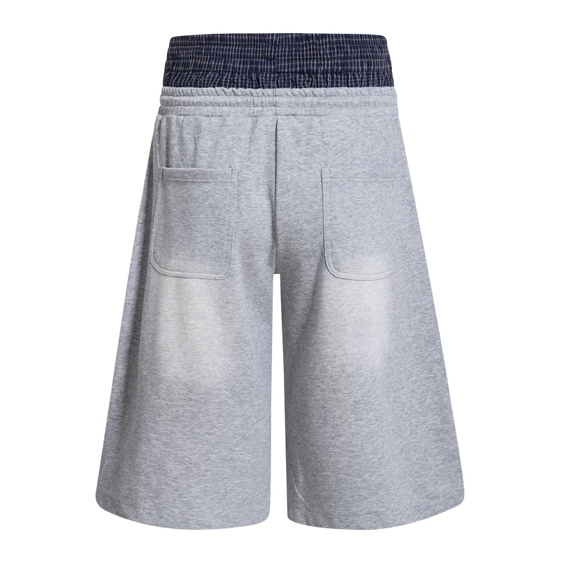 Back view of light gray athletic shorts with navy plaid double waistband and patch back pockets