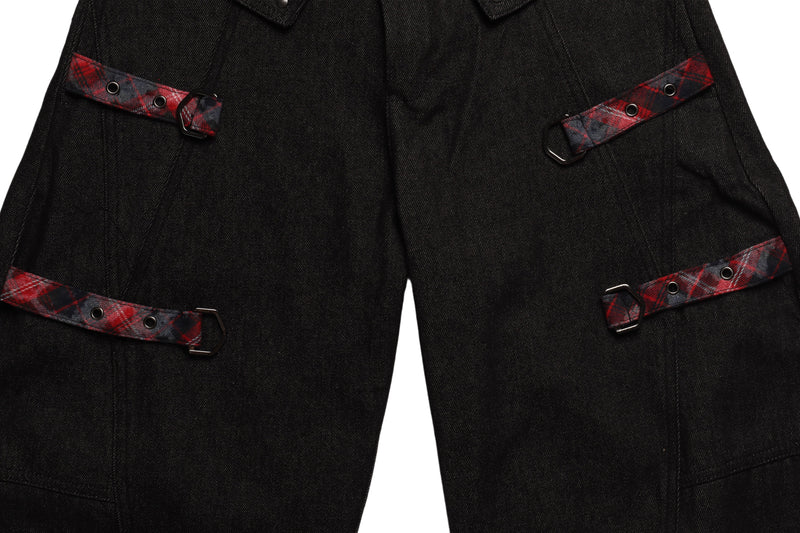 Close-up of black denim cargo pockets with red plaid flap straps and metal rings