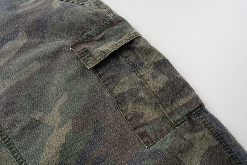 Close-up of the side cargo pocket and stitched seam on camouflage shorts