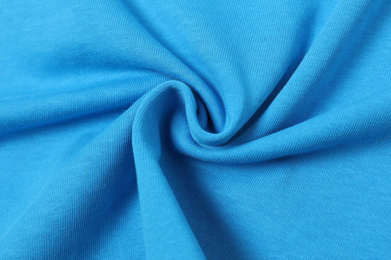 Close-up of bright blue jersey knit fabric with soft folds and ribbed texture, styled for a varsity streetwear tee