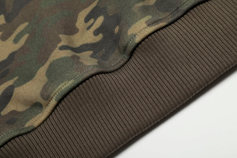 Lower hem of camo hoodie with brown ribbed waistband and seam stitching