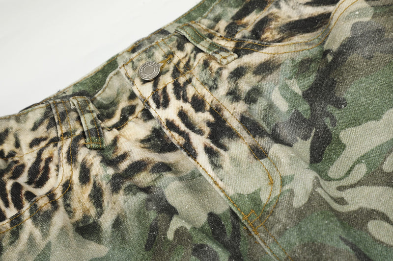 Close-up of front pocket and button detail on green leopard camo cargo shorts
