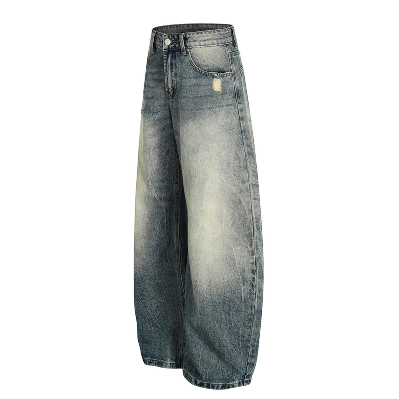 Three-quarter front view of faded blue wide-leg jeans with a distressed pocket and loose leg shape