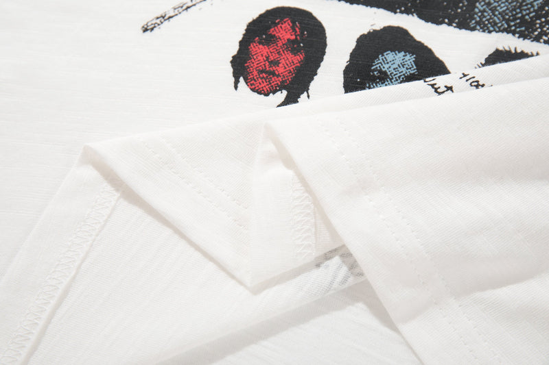 White vintage graphic tee with folded fabric and a distressed band poster print in red, blue, and black accents