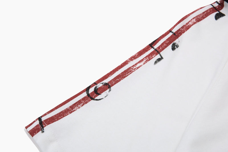 White men’s polo shirt sleeve with distressed red and black music-note graphic print