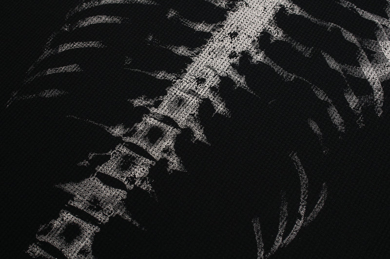 Close-up of black tee back print showing spine and rib x-ray graphic