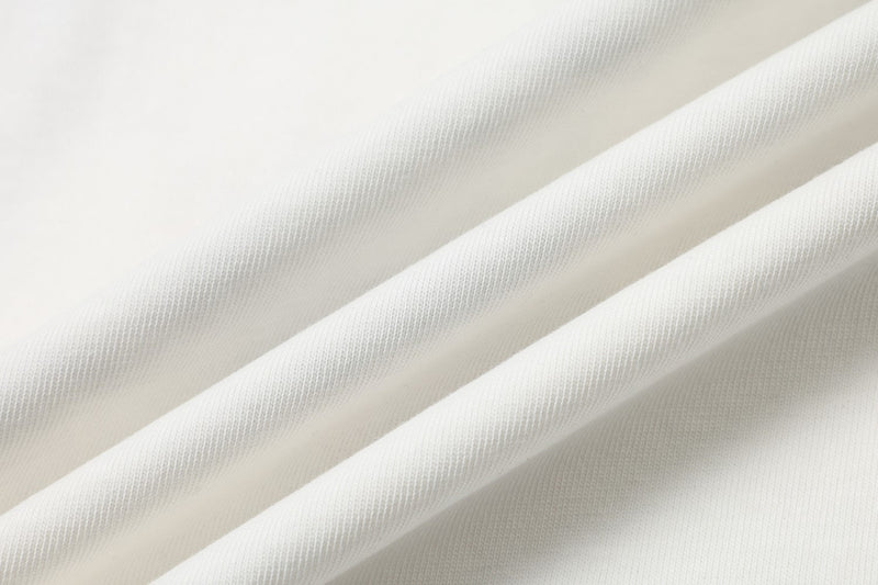 Close-up of soft white washed fabric with subtle ribbed texture and draped folds for an oversized vintage tee