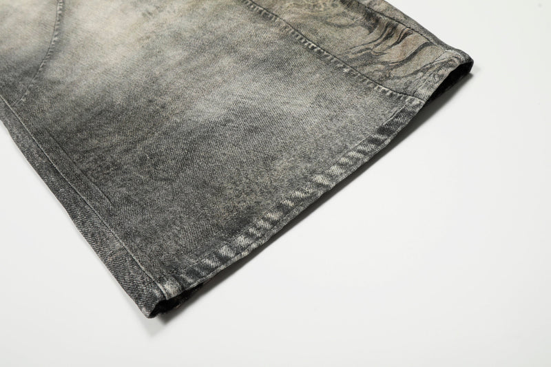 Close-up of hem on gray washed denim pants with curved leg shape