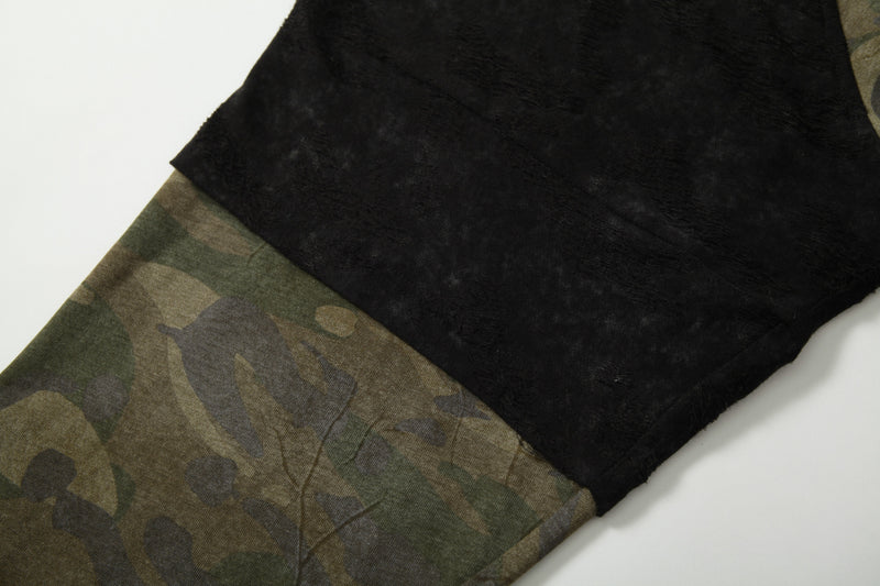 Close-up of black fuzzy sleeve panel joined to camo body on long sleeve tee