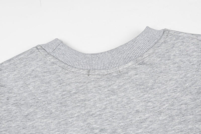 Close-up of heather gray ribbed crew neck and shoulder seam on the tee