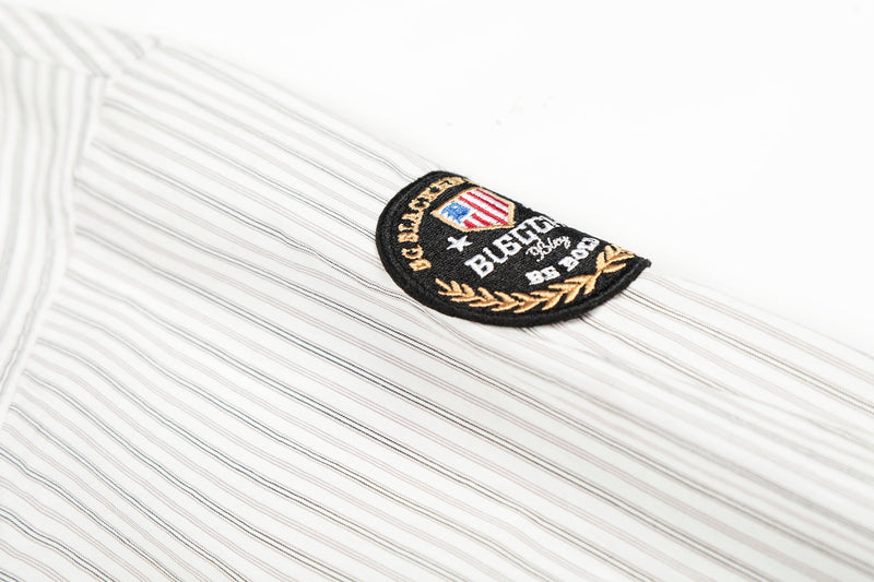 Close-up of sleeve patch embroidered on cream striped shirt