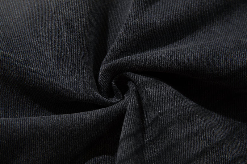 Close-up of dark denim fabric texture with folded crease detail