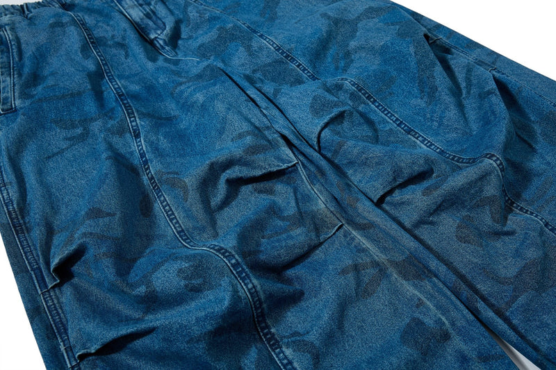 Close-up of front leg panel showing faded camo pattern on blue denim