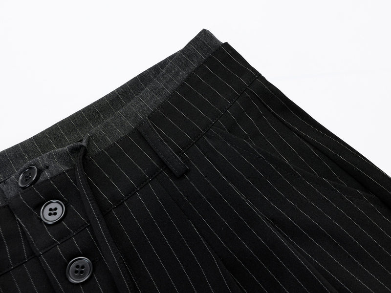 Close-up of black pinstripe shorts waistband and top front buttons