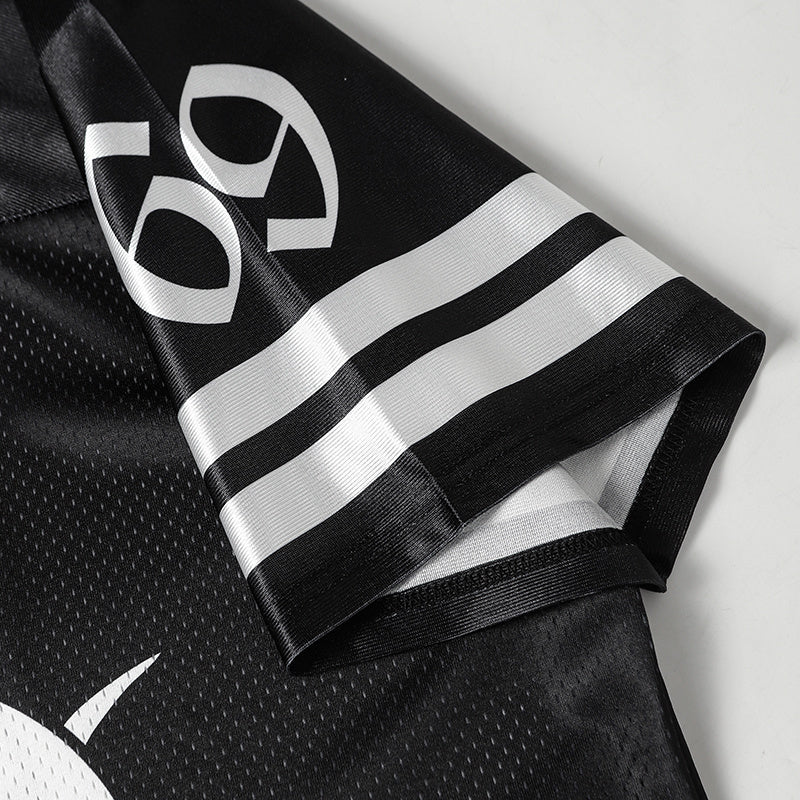 Black mesh football jersey with white graphic emblem and striped sleeve detail, shown in a close-up streetwear style shot