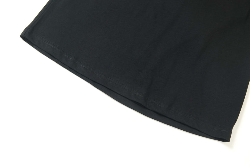 Black cotton graphic tee hem with neat stitching, featuring a street style star emblem design