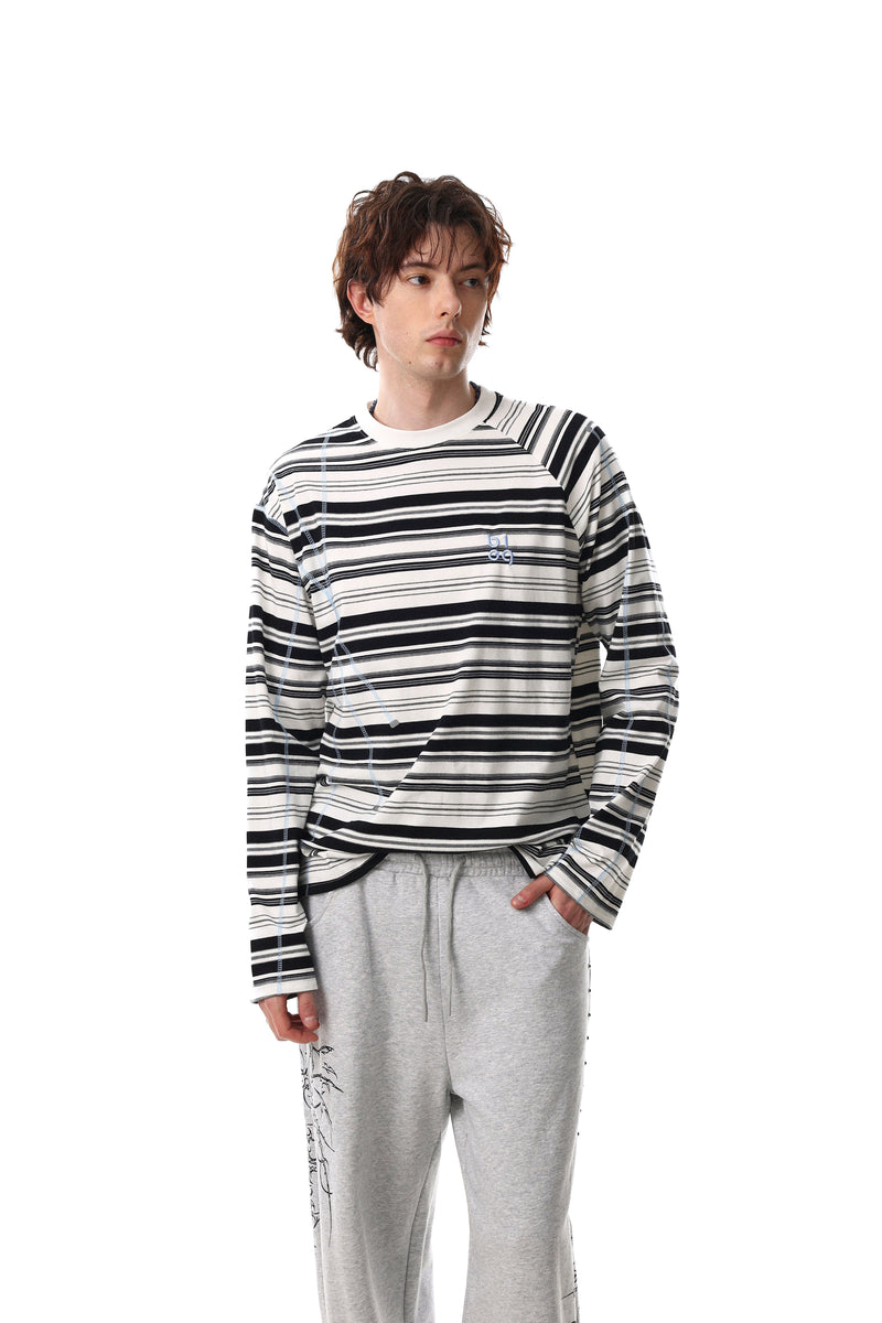 Black and white striped long sleeve tee worn with light gray pants, front model view