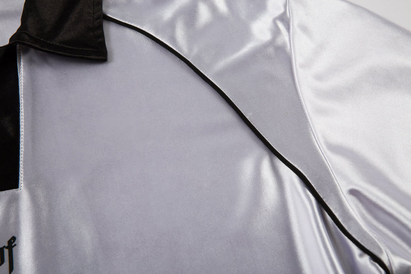 Close-up of white jersey back shoulder with black piping and collar edge