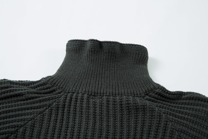 Close-up of dark green ribbed turtleneck collar on knit sweater