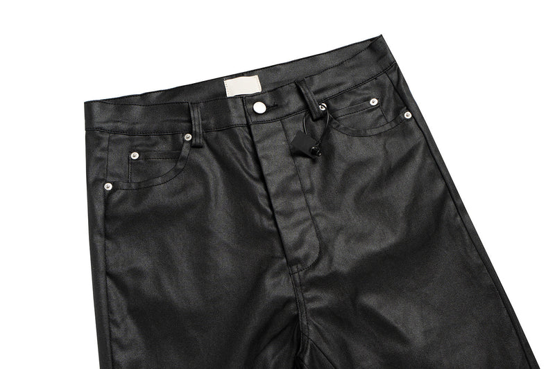 Waistband and front pockets of black leather-effect pants with snap button and drawstring