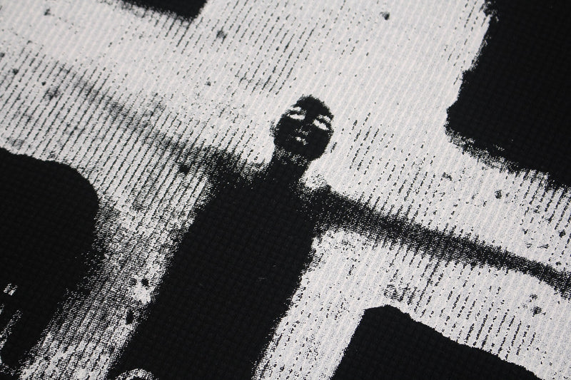 Black and white gothic cross graphic tee print with a hooded figure and distressed textured streetwear design
