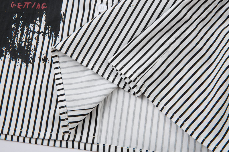 Close-up of striped sleeve and hem overlay with white inner layer and black long sleeve underneath