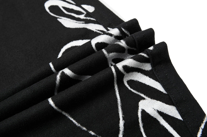 Close-up of white script print on black denim fabric folds