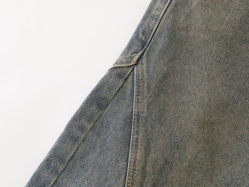 Close-up of the side seam panel on faded blue denim pants with contrast topstitching