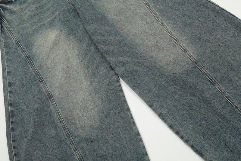 Denim pant leg close-up showing curved seam and faded vintage wash