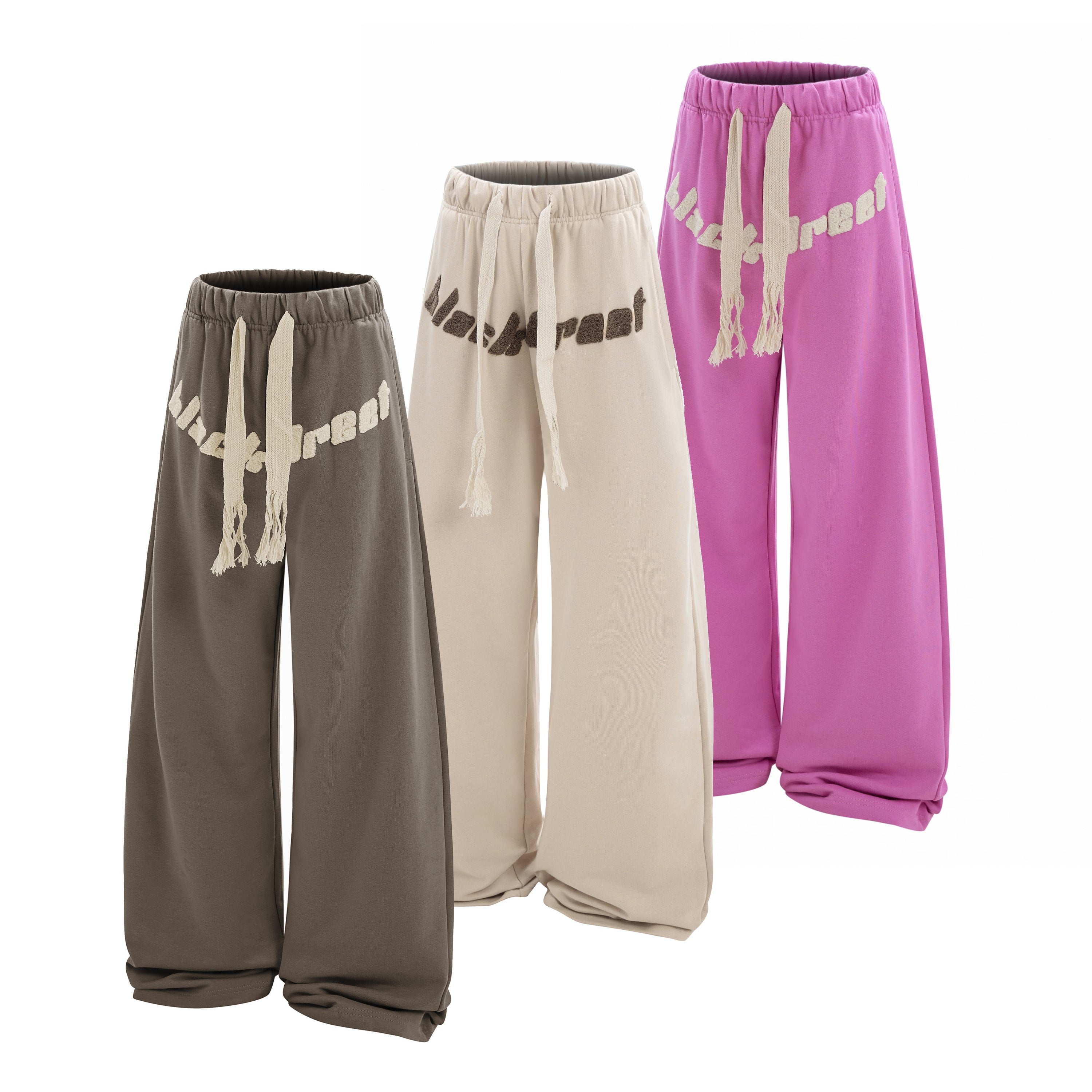 Omirad Black Rebel oversized wide-leg sweatpants in taupe, cream, and fuchsia pink with raised logo lettering and braided dra