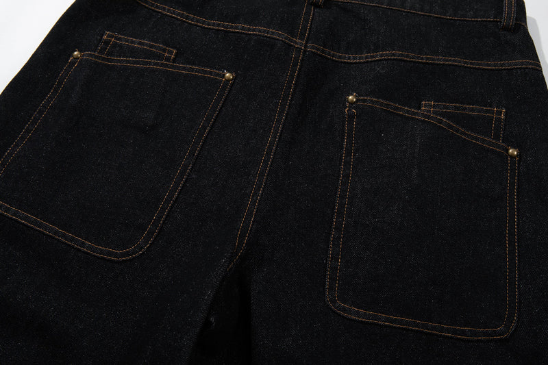 Close-up of the back pockets and seam stitching on black denim pants