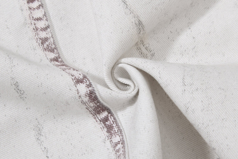 Close-up of twisted denim fold showing white washed fabric and brown seam detail