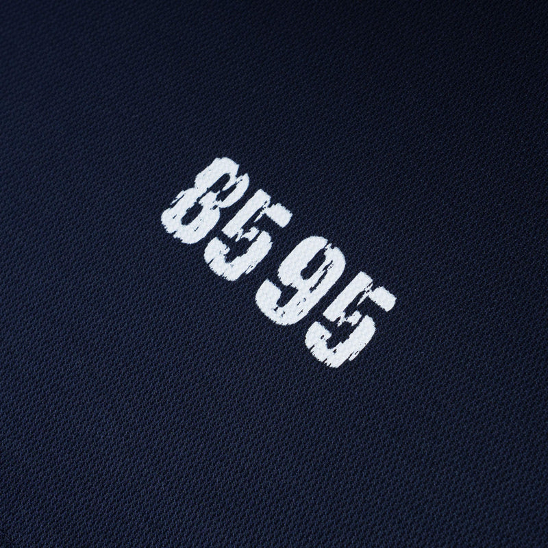 Close-up of navy cotton polo tee with distressed white 859 graphic print on the chest