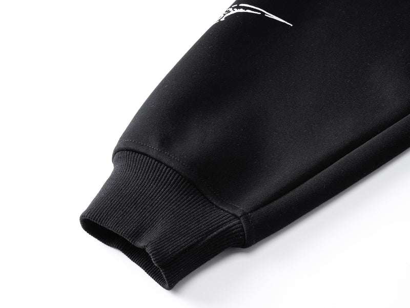 Close-up of black sleeve cuff with ribbed knit hem and smooth fabric